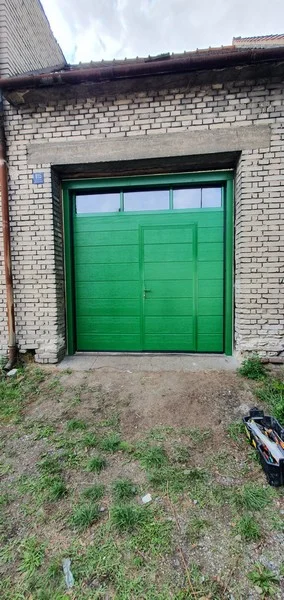 Sekční garážová vrata s dveřmi v zelené barvě ROLLO